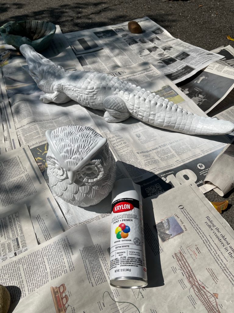 sculptures on newspaper being painted